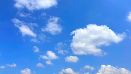 Blue sky background with white clouds in summer. Soft white clouds float in the clear blue sky. Clear blue sky, bright spring, soft sky gradient, wallpaper landscape, aerial view.