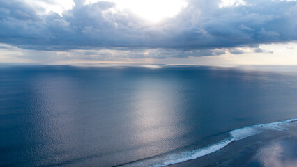 Luftaufnahme über den weiten Ozean mit glatter Wasseroberfläche und Wolkenhimmel