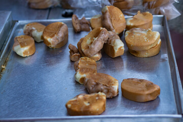 Traditional Indonesian street snack, pukis cake, freshly baked, placed on a metal tray, is ready to be sold. Popular for its soft texture and sweet taste, often sold by roadside vendors.