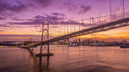 Urban Suspension Bridge with Purple Sky and Glowing Lights