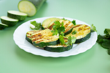 Textured fried zucchini on a plain green background