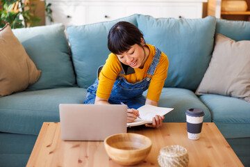 Woman having phone conversation while working remotely from home
