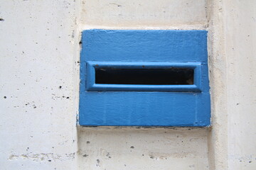 Boite aux lettre en métal peinte en bleu sur un mur