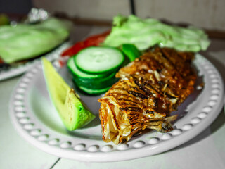 Fried lionfish with vegetables dish (pterois volitans) cooking presentation