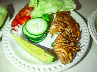 Fried lionfish with vegetables dish (pterois volitans) cooking presentation