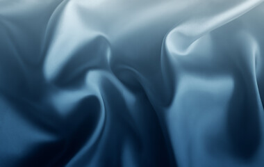 Shimmering folds of smooth fabric in cool shades of ice blue, steel, navy, and mist. The soft waves and silky surface create a fluid, luxurious atmosphere with elegant light reflection and depth.