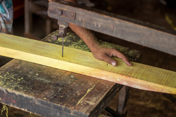 A worker is using a saw to cut wood.