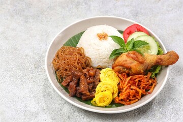 Nasi uduk is a dish made from diaroned white rice steamed with coconut milk, and seasoned with...