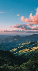 Panoramic mountain vista at sunset. Lush green valleys, rolling hills, and dark forests meet a vibrant sky