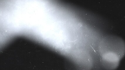 Light leak with dust particles and scratches on a textured black background, creating a vintage film overlay effect
