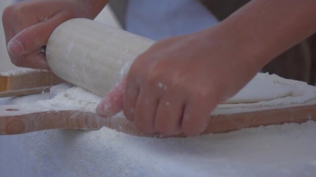 Traditional bread baking, kneaded dought of flour and water rolled with pin,
