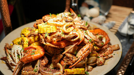 Stir-fried seafood with special sauce served with vegetables on a plate