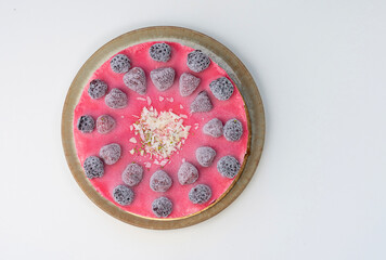 Whole Frozen Berry Cheesecake with Pink Glaze and White Chocolate Shavings on White Background