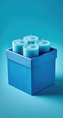 Fototapeta premium Four teal tealight candles nestled in a teal square box on a teal background