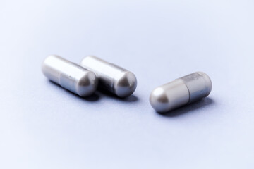 Naklejka premium Amino acids capsules on bright background. Soft focus. Close up. Copy space. 