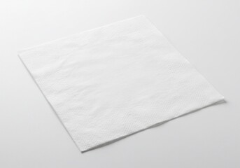 Clean white square paper napkin on a bright white surface, slightly angled.
