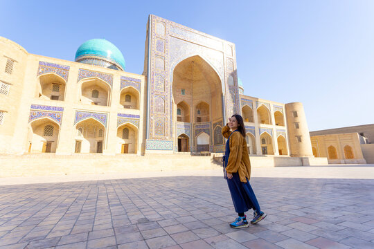 woman as a tourist have fun in front of Poi-Kalyan Kalyan mosque in bukhara Uzbekistan	