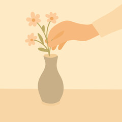 A delicate hand placing fresh flowers into a vase on a clean tabletop — a calming, minimal scene of mindful living.