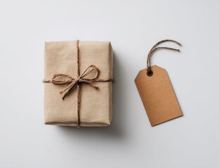 A simple, wrapped gift box with a tag, set against a plain white background.  The box is kraft paper, tied with twine.  A tan tag sits beside it.  Neutral and minimalist