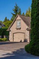 Garage door in luxury house with trees and nice landscape in Summer in Vancouver, Canada, North America. Day time on July 2025.
