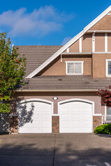 Garage door in luxury house with trees and nice landscape in Summer in Vancouver, Canada, North America. Day time on July 2025.