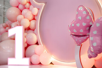 Birthday party for 1 year old girl on a background photo wall. Decorated with helium balloons.
