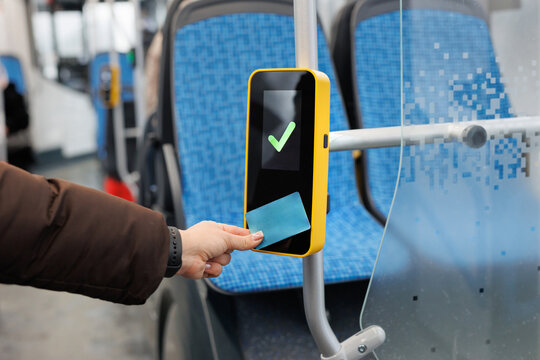 Woman hand paying contactless with plastic card for the public transport in bus.