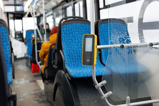 Paying contactless with plastic card for the public transport in bus. Payment terminal in the bus.