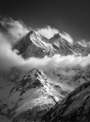Obraz premium Dramatic snow-capped peaks emerge from a cloudy sky