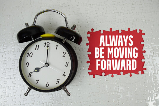 Always Be Moving Forward text with alarm clock on red background