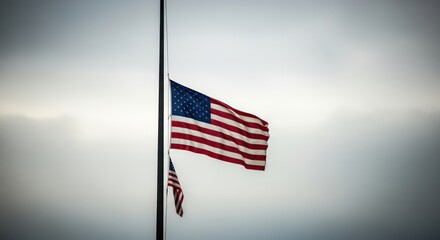 An American flag at half-mast waves solemnly against a dramatic, overcast sky in a sign of mourning.