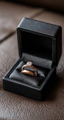A close-up of two gold wedding rings nestled in a black jewelry box