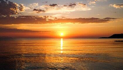 Obraz premium Serene Sunset over Calm Ocean Waters Golden Hour.