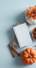 Autumnal flatlay with books, pumpkins, flowers, and spices