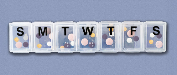 A plastic pill organizer box tablet dispenser closeup