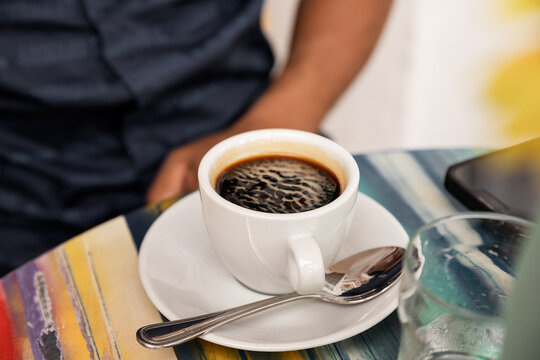 Closeup of hot black coffee in white cup on the table ready for man to drink