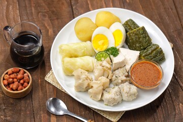 Siomay Bandung. Fish cake dumplings with potato, egg, and cabbage roll served with peanut, chili, sweet soy sauces and lime