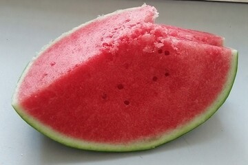 Whole and slice of ripe watermelon, heap of watermelon slices as background