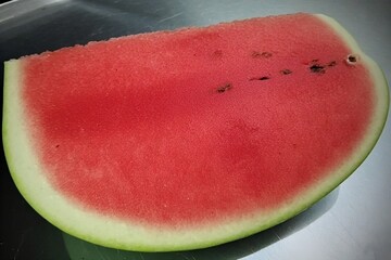 Whole and slice of ripe watermelon, heap of watermelon slices as background