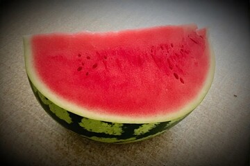 Whole and slice of ripe watermelon, heap of watermelon slices as background