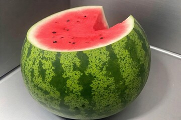 Whole and slice of ripe watermelon, heap of watermelon slices as background
