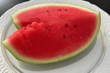 Whole and slice of ripe watermelon, heap of watermelon slices as background