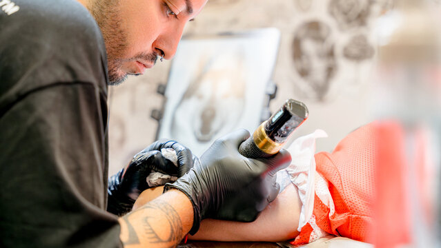 Tattoo artist concentrating on intricate design work