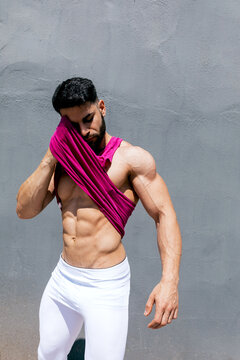 Athletic man in fitness attire against concrete wall
