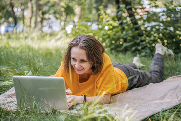 Woman using laptop outdoors in a park setting