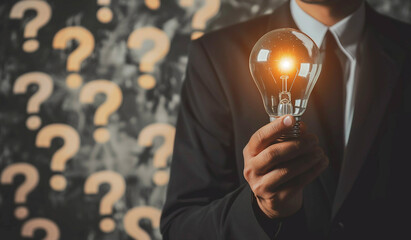 Problem-Solving Concept with a Businessman Holding a Glowing Light Bulb Solution