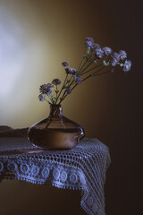 wild summer flowers in dark glass vase on dark blue background