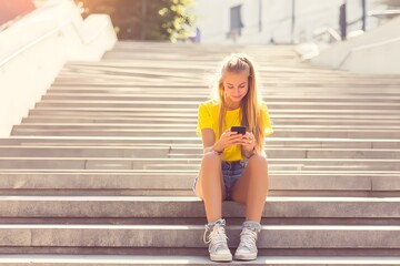 Obraz premium Teen girl texting on stairs in sunny outdoor setting Generative AI