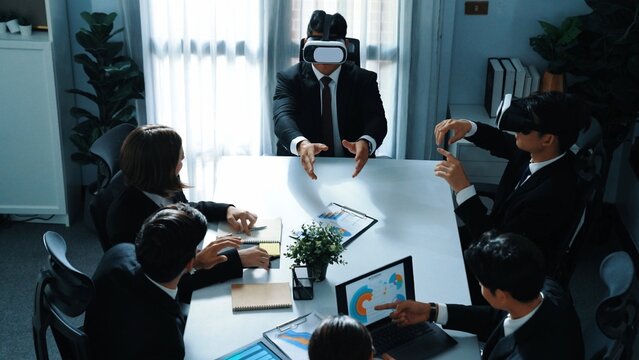 Top view of manager working on laptop and sending data analysis to business people by using VR glass headset while diverse team planning marketing strategy and looking at financial graph. Directorate. - Powered by Adobe