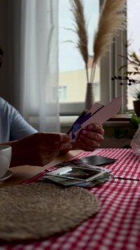 ederly hands flipping through old photographs, remembering the past with emotion